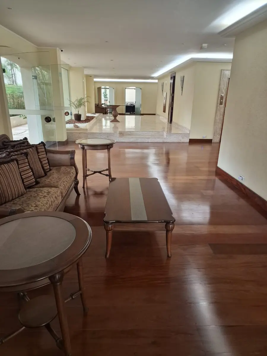 Assoalho escuro em hall mobiliado com sofá e mesas, Aplicadora Embuarte