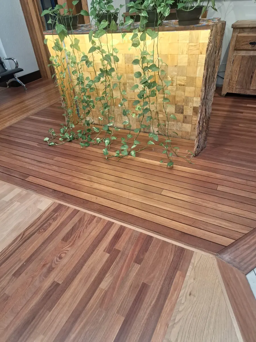 Piso de madeira em faixas distintas ao redor de ilha com plantas, Aplicadora Embuarte