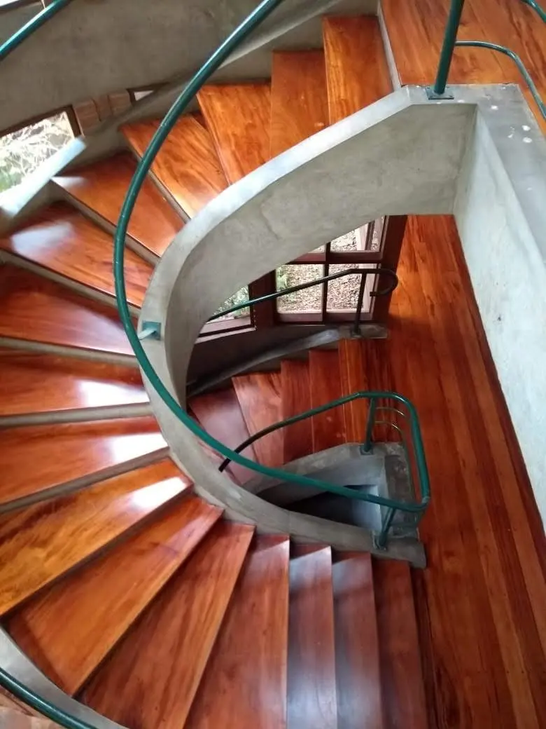Escada em caracol de madeira com corrimão verde e concreto, Aplicadora Embuarte
